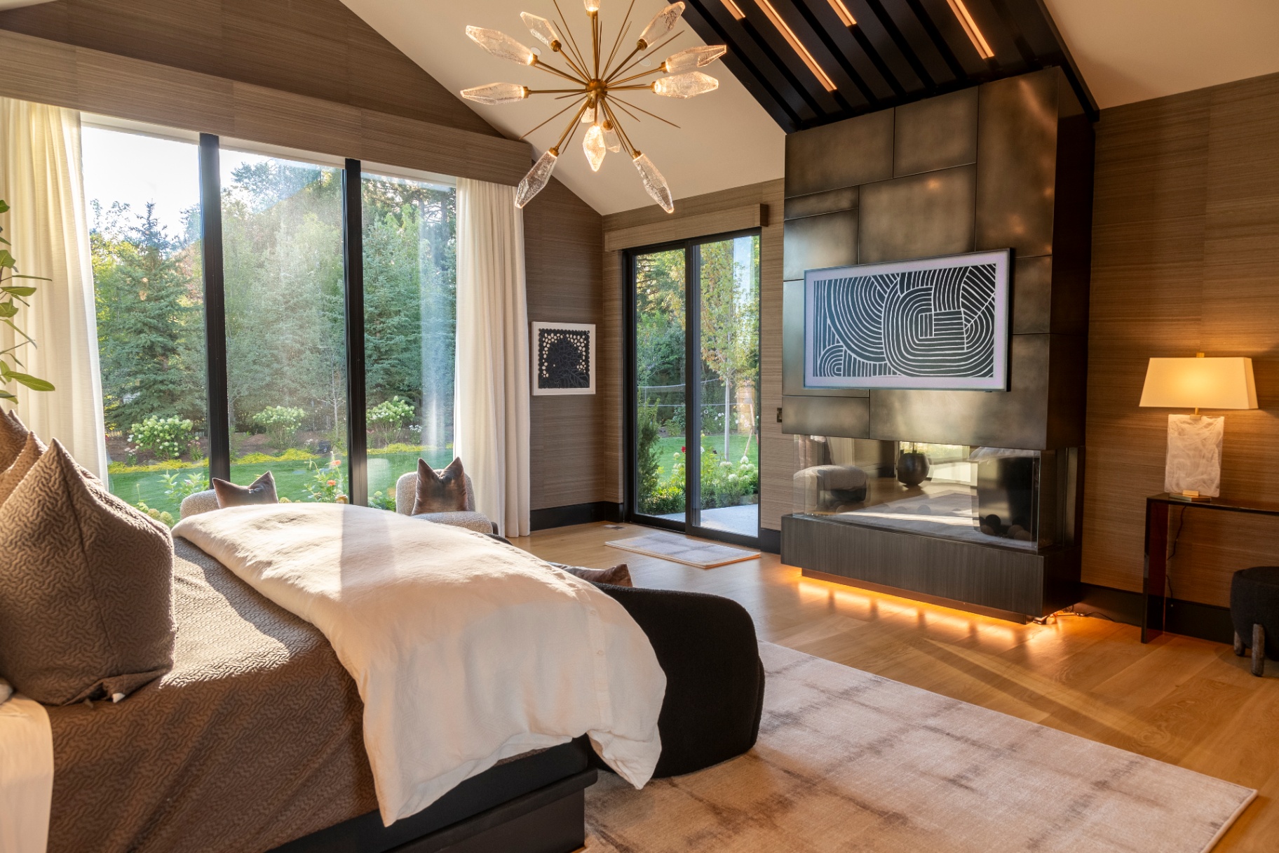 Luxury bedroom with integrated television above a modern fireplace