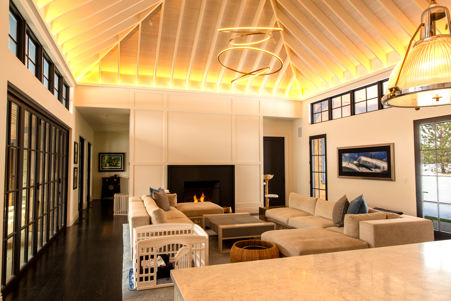 Luxury great room with warm indirect LED ceiling lighting and modern chandelier