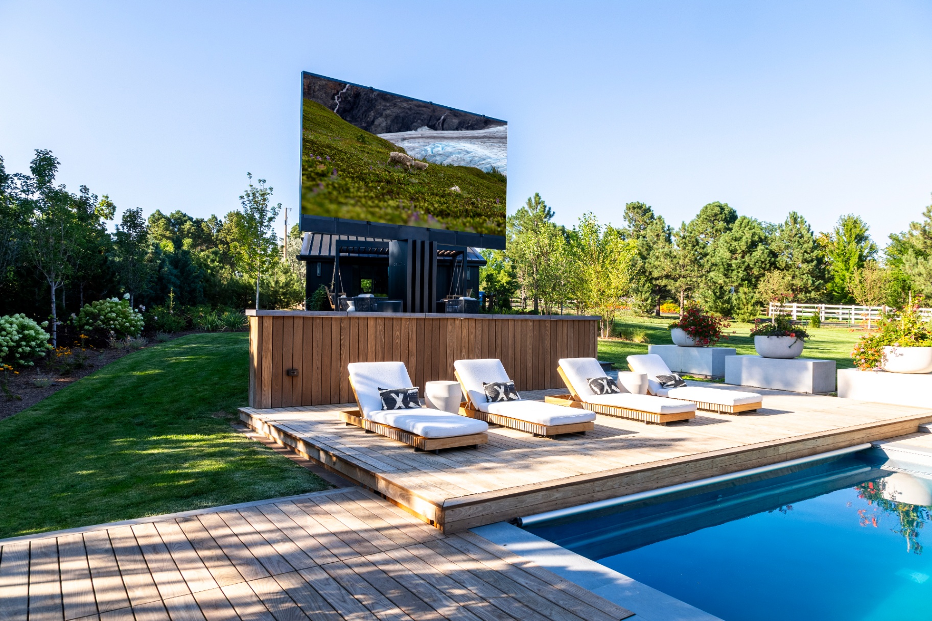 Poolside outdoor television with lounge chairs and a Colorado mountain backdrop