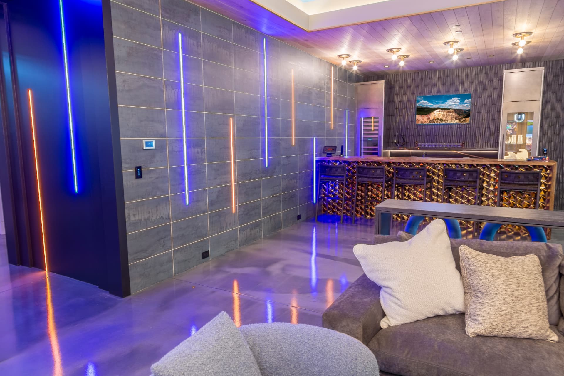 Lounge with linear color-changing accent lighting on a tiled feature wall