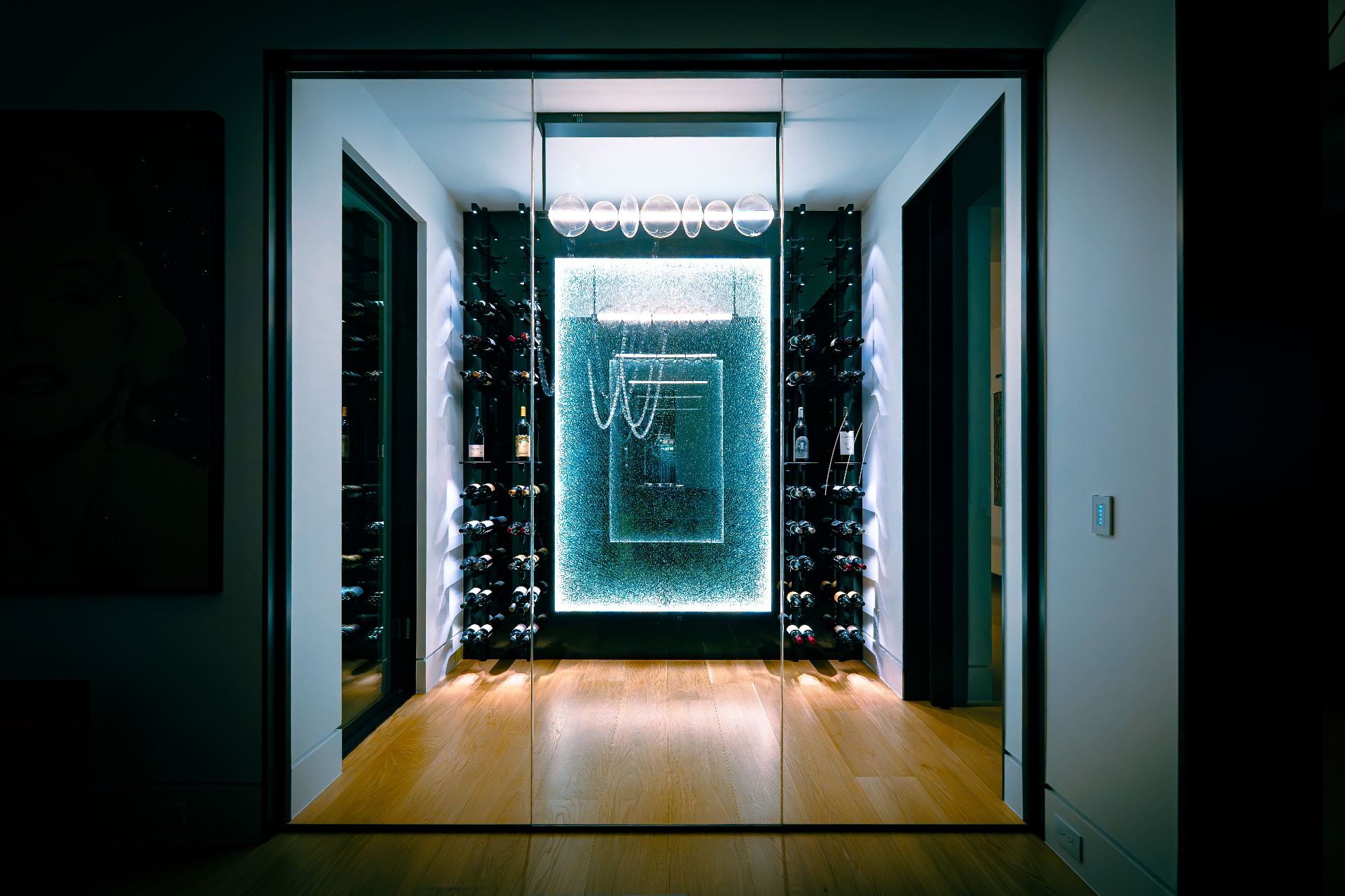 Backlit custom wine cellar with glass walls and integrated lighting