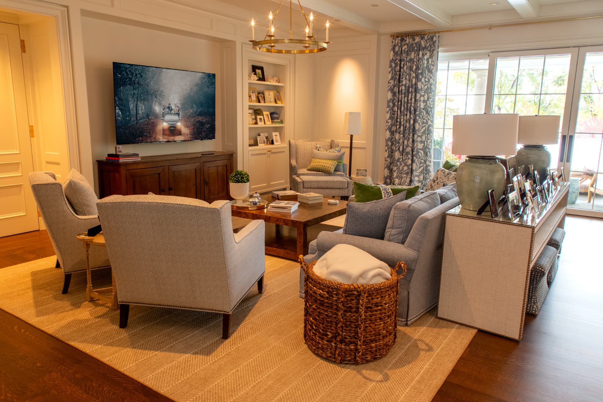 Traditional family room with a large wall-mounted television above an antique credenza
