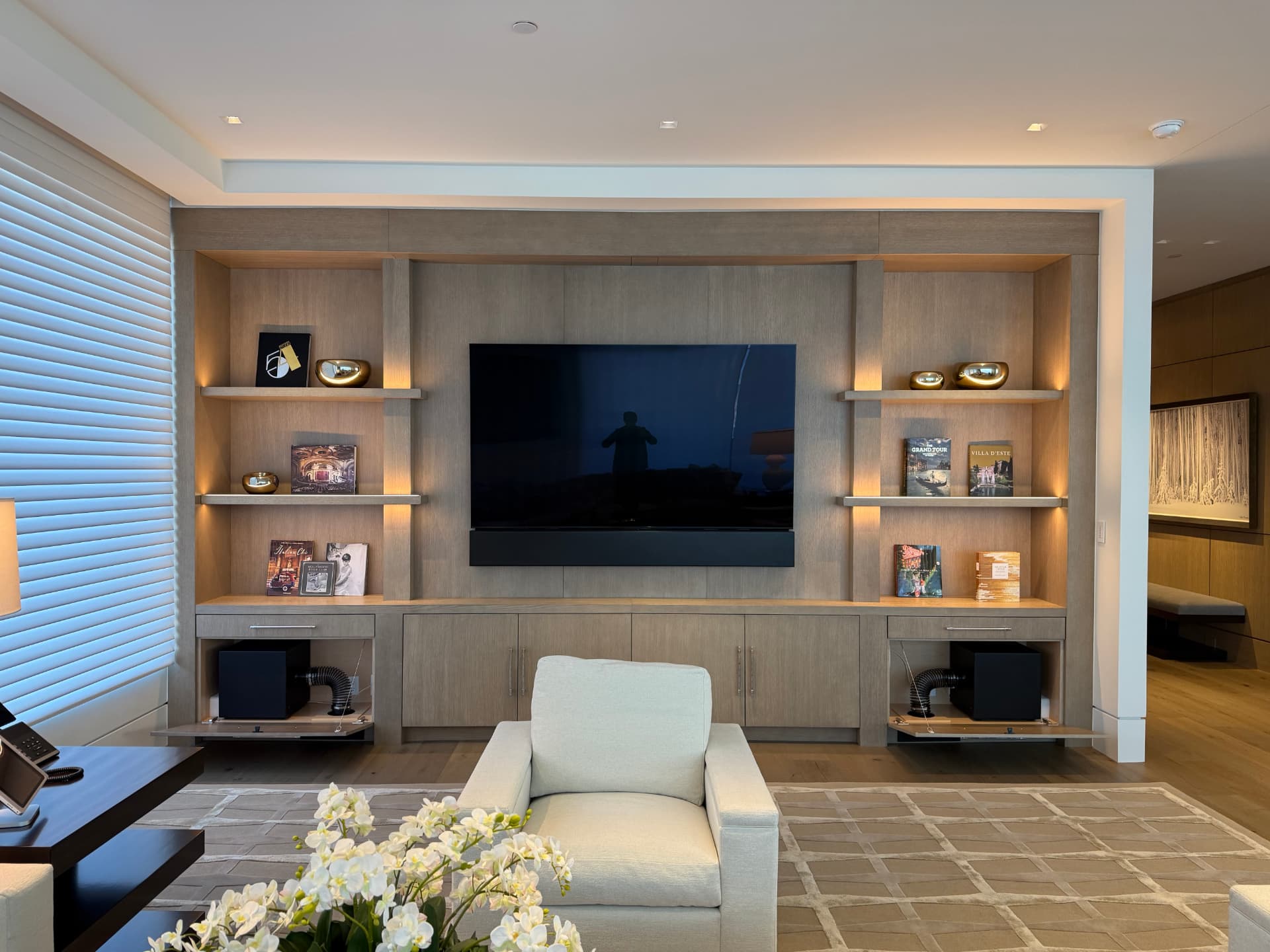 Entertainment wall with subwoofers hidden inside ventilated custom cabinets