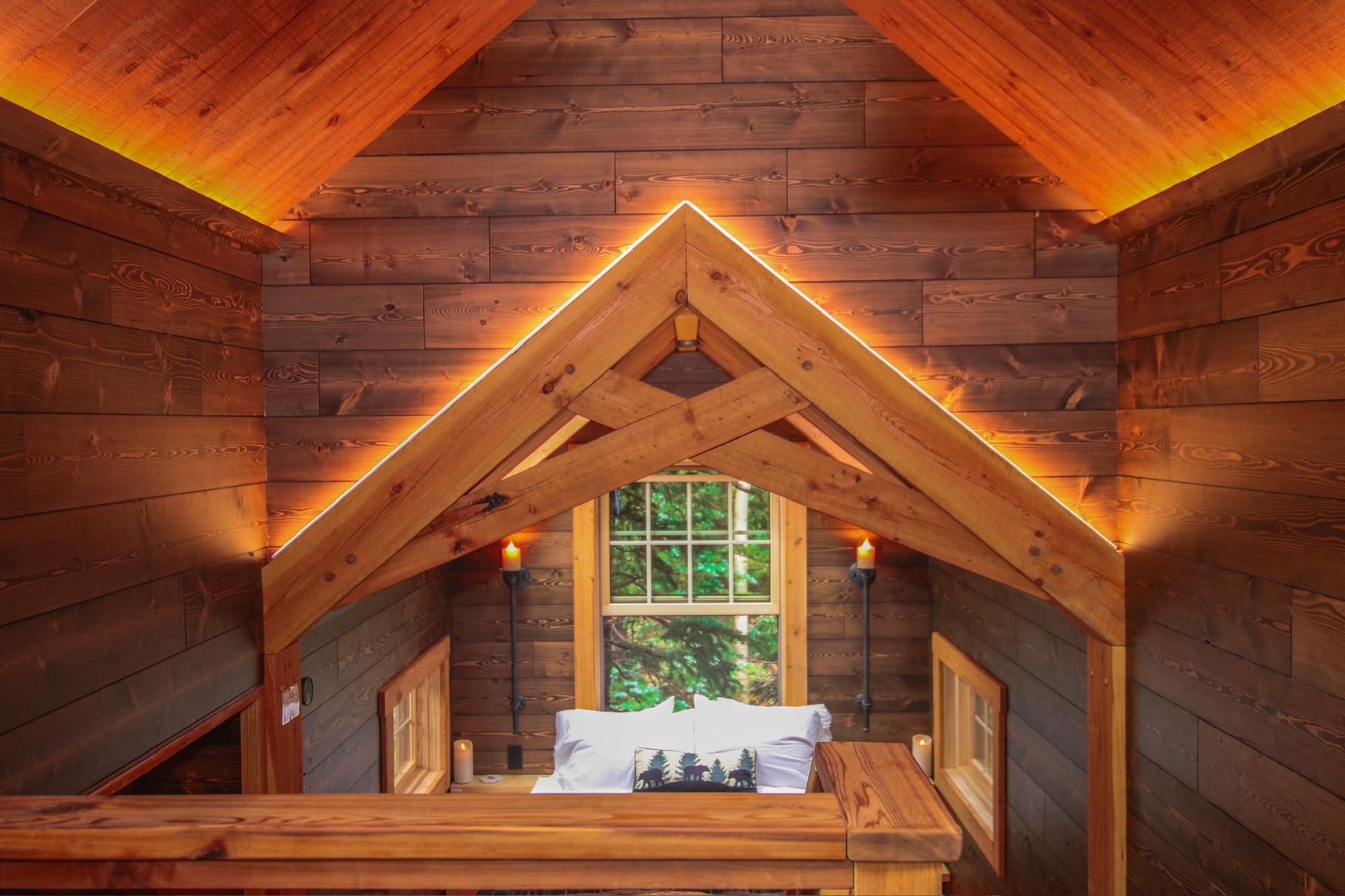 Cedar timber-framed loft with warm LED accent lighting along the roofline
