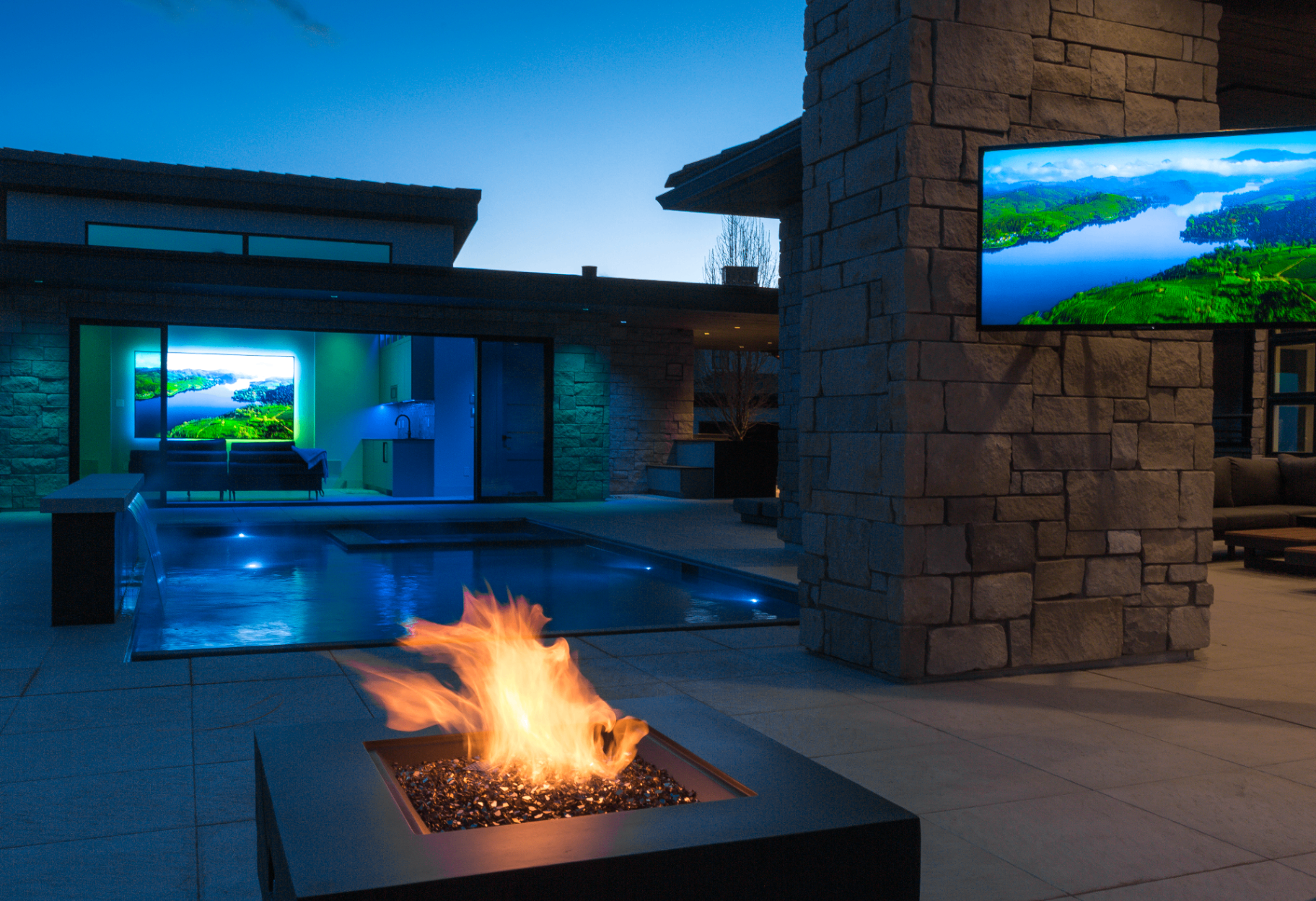 Outdoor fire feature and integrated poolside television at a luxury Colorado home