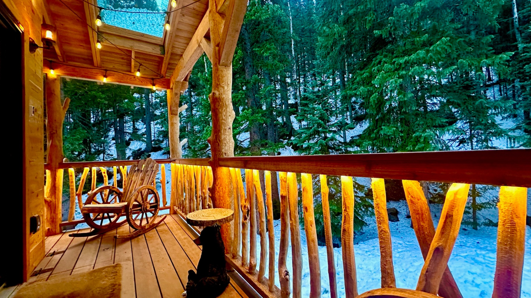 Wooded treehouse porch with warm accent lighting and string lights at dusk
